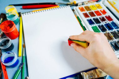 kadın ressam yanında yalan beyaz kağıt üzerinde renkli guaj ve suluboya çizer
