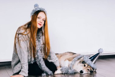 Noel ve yeni yıl 2018 için bekleyen onun köpeği ile katta oturan mutlu sevimli Kızıl saçlı kız