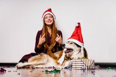 mutlu Kızıl saçlı kız köpeğiyle yere oturur, Noel ve yeni yıl kutluyor