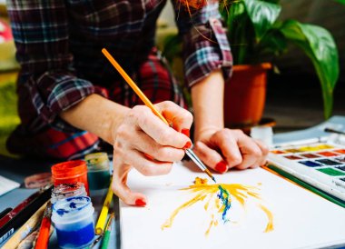 kadın ressam boyalar bir fırça ve beyaz kağıt üzerinde parlak boyalar