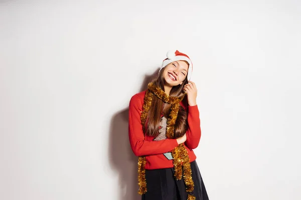 Gelukkig lachen meisje in een rode Pet en met een gouden klatergoud rond haar nek vieren het nieuwe jaar 2018 en kerst — Stockfoto