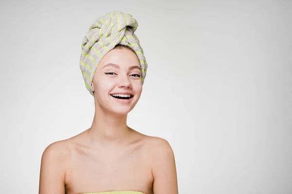 Glückliches junges Mädchen mit einem Handtuch auf dem Kopf genießt einen Wellnessbereich — Stockfoto