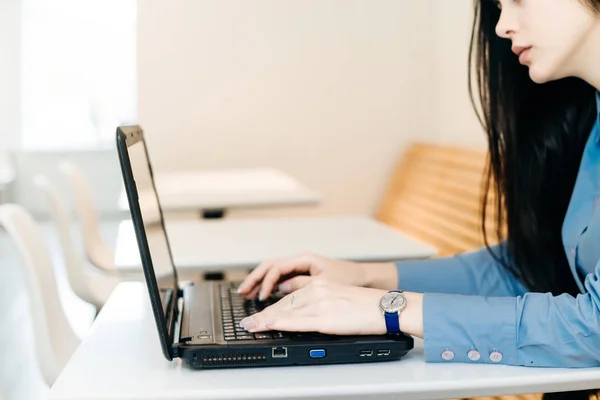 Freelancer de cabelos pretos menina em camisa azul trabalhando no laptop — Fotografia de Stock