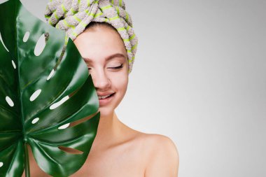 mutlu genç kız yaprak yeşil tutan bir spa zevk başında bir havlu ile