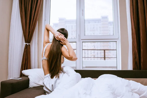 Kobieta rozciąga się na łóżku, po przebudzeniu — Zdjęcie stockowe