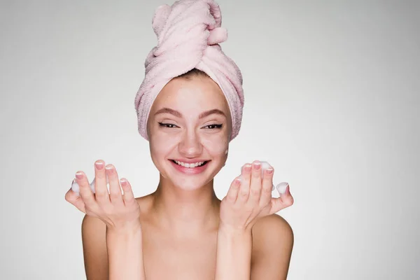Счастливая женщина с полотенцем на голове положить на лицо пены — стоковое фото