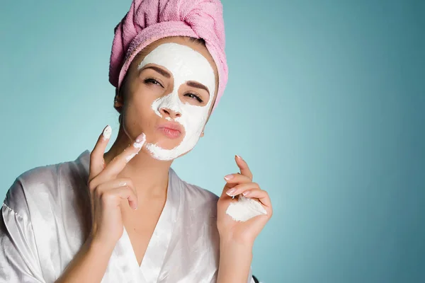 Woman with a towel on her head puts a mask on her face — Stock Photo, Image