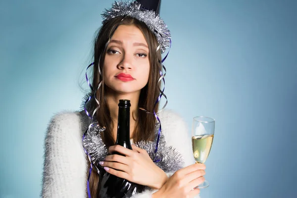 Пьяная женщина в праздничной кепке на голове пьет шампанское — стоковое фото