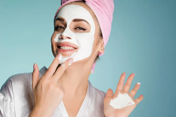 Glückliche Frau mit Handtuch auf dem Kopf setzt Maske aufs Gesicht — Stockfoto