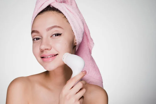 Donna felice con asciugamano sulla testa spazzolatura viso per la pulizia profonda — Foto Stock