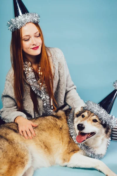 여자는 새 해에 그녀의 강아지와 함께 바닥에 앉아 — 스톡 사진
