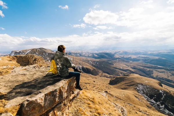 Женщина турист сидит на фоне гор — стоковое фото