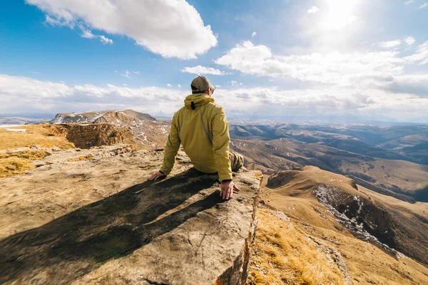 Maschio turista è seduto e guardando le montagne — Foto Stock