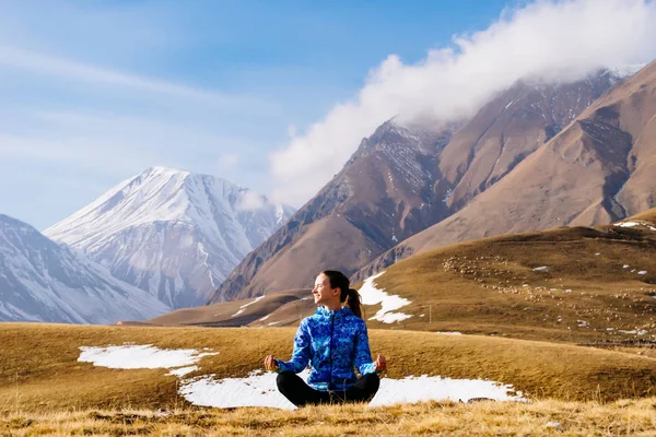Touristin meditiert vor dem Hintergrund hoher Berge — Stockfoto
