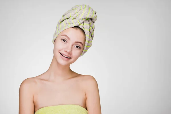 Bela menina sorridente com uma toalha na cabeça desfrutando de tratamentos de spa — Fotografia de Stock