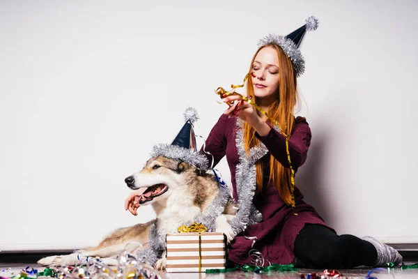可爱的 red-haired 女孩坐在地板上与她的狗和庆祝新年2018 — 图库照片