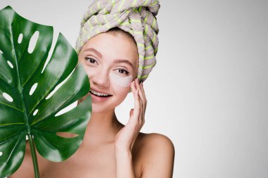 holding bir yaprak yeşil, gün spa başında bir havlu ile sevimli gülümseyen kız