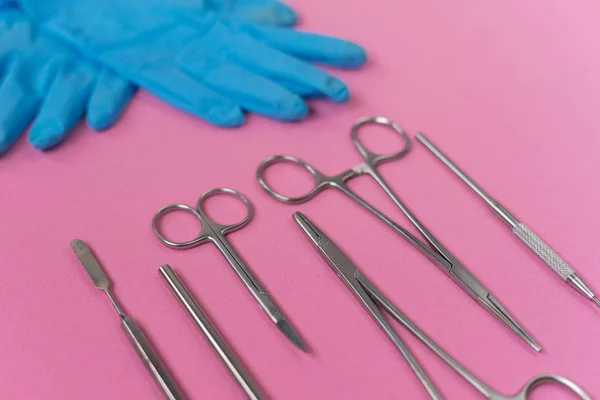 En la superficie rosa son instrumentos dentales y guantes azules — Foto de Stock