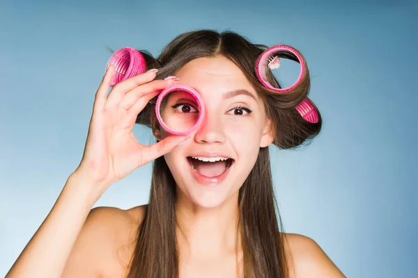 Счастливая молодая девушка хочет быть красивой, на голове и в руках большие розовые бигуди — стоковое фото