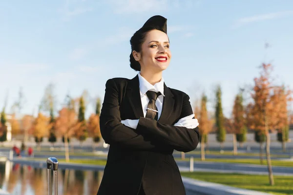 Happy usměvavá letuška žena v uniformě vyhledá na oblohu a myslí na lety — Stock fotografie