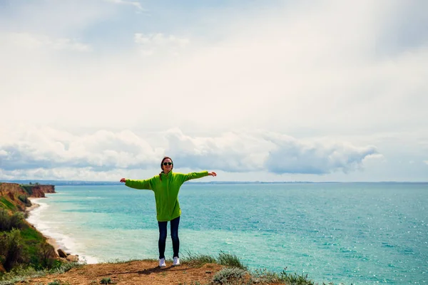 Attiva ragazza con una felpa verde viaggia, contro il mare — Foto Stock