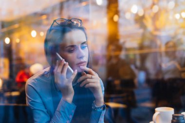 oldukça meşgul bir kafede oturmuş telefonda pazarlık mavi gömlekli kız serbest meslek