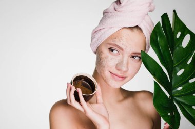 Onun yüzünde bir kahve Maki koymak bir yaprak yeşil kafasındaki bir havlu ile mutlu genç kız tutar