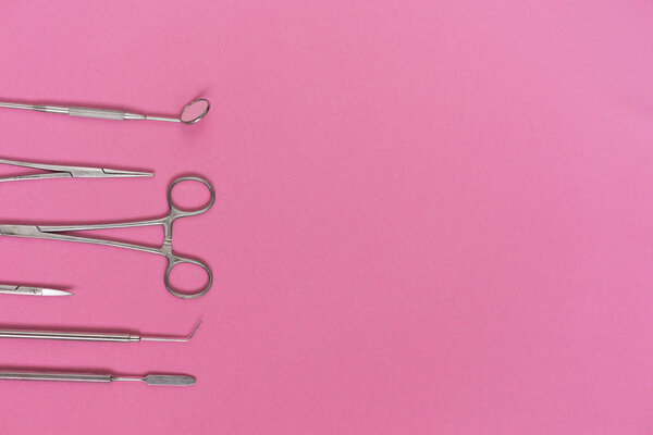 on the pink surface are medical dental instruments