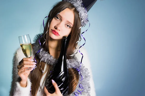 Грустная молодая пьяная девушка в кепке празднует Новый год, держит в руках шампанское — стоковое фото