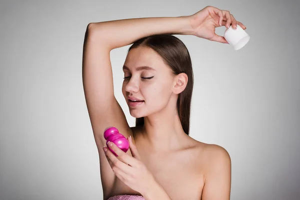Bella ragazza attraente mette deodorante aromatico sulle ascelle — Foto Stock