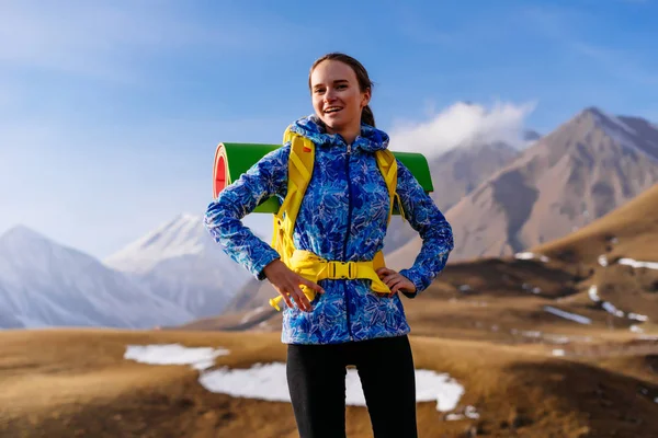 Młoda dziewczyna szczęśliwy w Błękitnej Kurtki przemieszcza się wzdłuż grzbiet kaukaski z plecaka i namiot — Zdjęcie stockowe