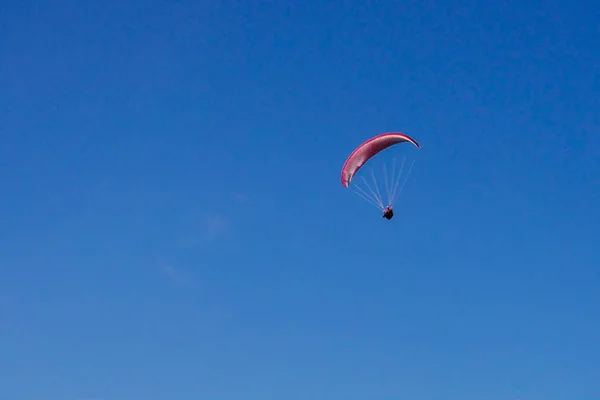 Červené letadlo letí na modré obloze — Stock fotografie