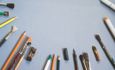 birçok Sanat fırçalar ve kalem mavi masaya vardır