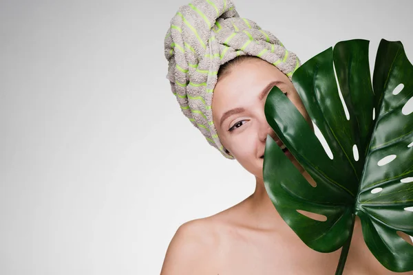 stock image cute young girl with a towel on her head holds a green leaf, enjoys a spa