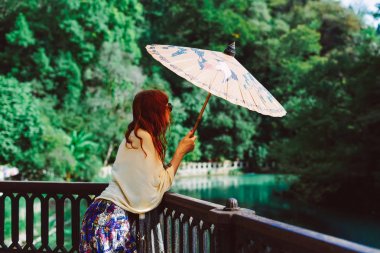 Kızıl saçlı kadın kesiminden Park Çin bir şemsiye ile sahiptir