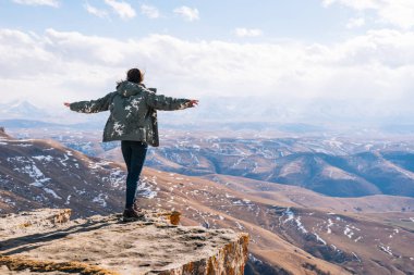 bir kadın turist bir dağ kenarında duruyor