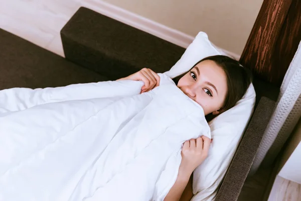 Женщина лежит в постели под одеялом — стоковое фото