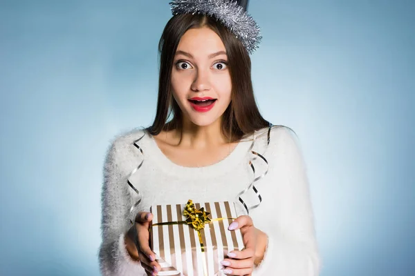 Vrouw in een feestelijke hoed houdt een geschenk in haar handen — Stockfoto