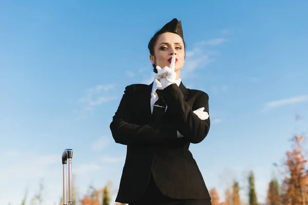 Стюардесса в форме против голубого неба — стоковое фото