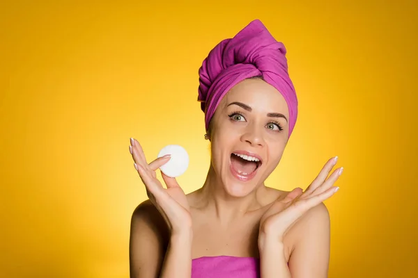 Kvinna med en handduk på huvudet håller en bomullstuss i händerna — Stockfoto