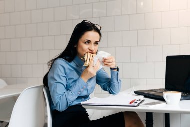 vasıl belgili tanımlık yazıhane masada oturan ve bir sandviç yeme kadın