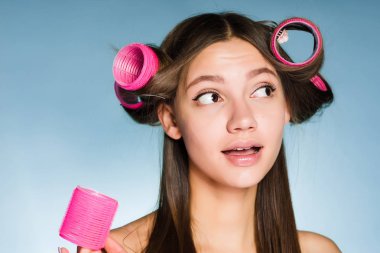 mavi bir arka plan üzerinde başında curlers kadınla