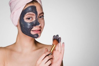 kadının kafasındaki bir havlu ile yüz cilt arındırıcı maske uygulamak