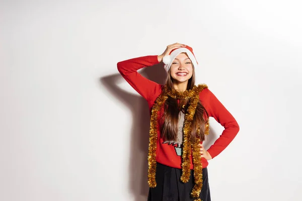 Glückliche Frau mit Weihnachtsmütze auf grauem Hintergrund — Stockfoto
