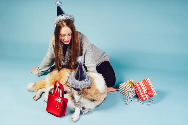 Vrouw in een Nieuwjaar hoed zit naast een hond — Stockfoto