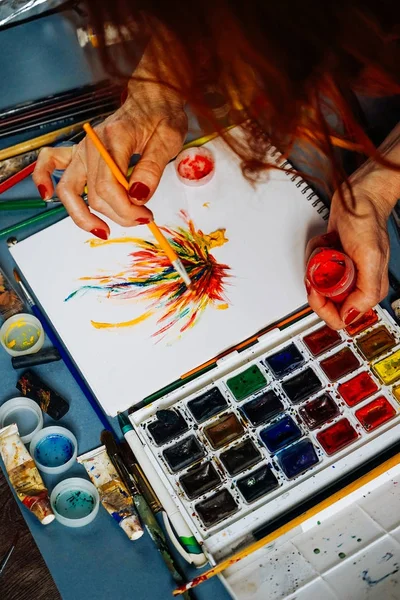 Žena malíř barvy na bílém papíře v vícebarevné nátěrové hmoty — Stock fotografie