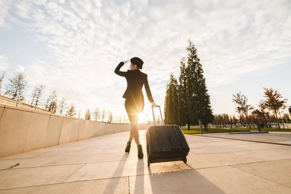 Stewardess in Uniform trägt einen großen Koffer — Stockfoto