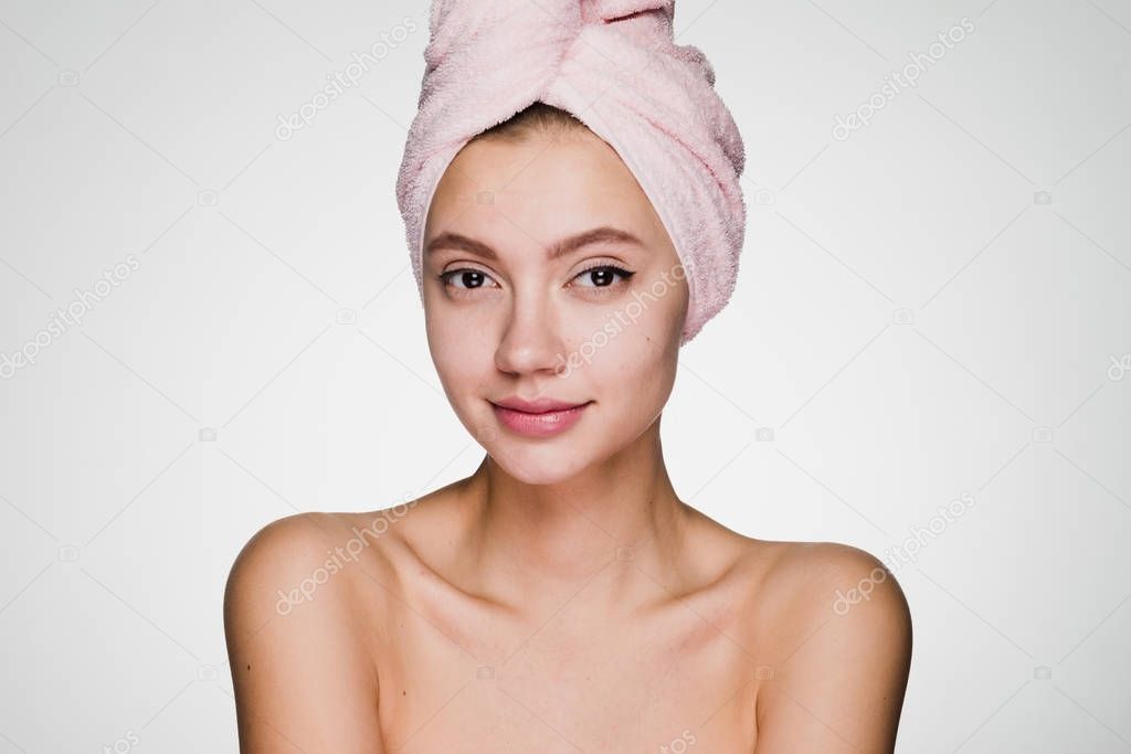 happy woman with a towel on her head on a gray background