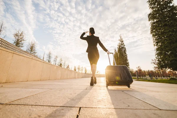 woman in flight stewardess carries a large suitcase