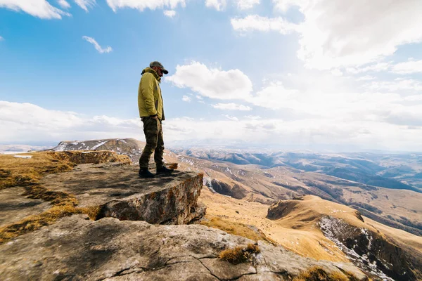 Güneşli bir günde dağlar zemine karşı duran erkek turist — Stok fotoğraf